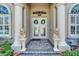 Elegant front door entrance, flanked by lion statues and flowerbeds, offering classic curb appeal at 565 Osprey Landing Dr, Lakeland, FL 33813