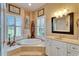 Corner soaking tub and glass shower with tile surround in a bright main bathroom at 565 Osprey Landing Dr, Lakeland, FL 33813