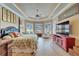 Spacious main bedroom with tray ceiling, ceiling fan, wood floors, sitting area, and plantation shutters at 565 Osprey Landing Dr, Lakeland, FL 33813