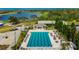 A beautiful community pool features lounge chairs, tables, and a serene lake backdrop for relaxation at 565 Osprey Landing Dr, Lakeland, FL 33813