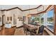 Traditional dining room featuring a chandelier, wood flooring, and large windows overlooking the pool and backyard at 5676 Case Ln, Lakeland, FL 33813