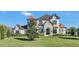 Elegant two-story home with lush landscaping, a stone facade, and a manicured lawn at 5676 Case Ln, Lakeland, FL 33813