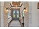 An inviting foyer with stone archways, a wood plank ceiling, decorative lighting, and stylish decor at 5676 Case Ln, Lakeland, FL 33813
