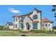 Gorgeous two-story home highlighting the stone detailing, arched windows, and pristine landscaping at 5676 Case Ln, Lakeland, FL 33813