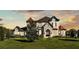 Beautiful two-story home showcasing manicured lawns and a detailed stone facade at sunset at 5676 Case Ln, Lakeland, FL 33813