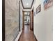 Inviting hallway with wood floors, custom trim, and elegant artwork, offering a glimpse into other rooms at 5676 Case Ln, Lakeland, FL 33813