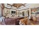 Spacious living area featuring a stone fireplace, coffered ceilings, a stylish bar, and comfortable seating at 5676 Case Ln, Lakeland, FL 33813