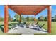 View of pergola-covered outdoor living room with a built-in firepit and comfortable seating for guests at 5676 Case Ln, Lakeland, FL 33813