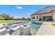 A luxurious backyard pool with chaise loungers and fire features provides a serene oasis, complemented by outdoor dining at 5676 Case Ln, Lakeland, FL 33813