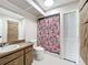 Bathroom with wood vanity, sink, toilet, shower and floral shower curtain at 6305 Tocobega Dr, Lakeland, FL 33813