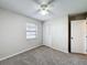 Cozy bedroom features carpet flooring, a ceiling fan, a window, and a closet at 6305 Tocobega Dr, Lakeland, FL 33813