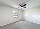 Carpeted bedroom offers ceiling fan, natural light through window with outdoor view at 6305 Tocobega Dr, Lakeland, FL 33813