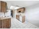 Traditional style kitchen with wood cabinets, white appliances, and tile flooring at 6305 Tocobega Dr, Lakeland, FL 33813