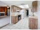 Open kitchen with wood cabinets, white appliances, and tile flooring at 6305 Tocobega Dr, Lakeland, FL 33813