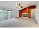 Cozy living room with a wood-paneled accent wall, fireplace, ceiling fan and sliding glass doors at 6305 Tocobega Dr, Lakeland, FL 33813