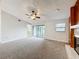 Spacious carpeted living room featuring a ceiling fan, sliding glass doors and a window at 6305 Tocobega Dr, Lakeland, FL 33813