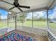 Relaxing screened porch features ceiling fan and views of the green backyard and blue skies at 6305 Tocobega Dr, Lakeland, FL 33813