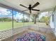 Screened porch with ceiling fan and a beautiful view of backyard and blue sky at 6305 Tocobega Dr, Lakeland, FL 33813