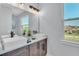 Bathroom featuring double vessel sinks, wood cabinets, and a large mirror at 6421 Highlands Oak Trl, Lakeland, FL 33813