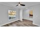 Bright bedroom with wood flooring, an elegant ceiling fan, neutral walls, and a large window at 6421 Highlands Oak Trl, Lakeland, FL 33813