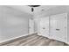 Neutral bedroom featuring wood floors, ceiling fan, and white closet doors at 6421 Highlands Oak Trl, Lakeland, FL 33813
