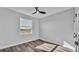 Bright bedroom with a ceiling fan, window view, and wood-look flooring at 6421 Highlands Oak Trl, Lakeland, FL 33813