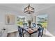 A dining area has a wood table set for four, natural light and backyard views through two windows at 6421 Highlands Oak Trl, Lakeland, FL 33813