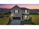 Charming two-story home with a modern, light-colored facade and inviting front porch at twilight at 6421 Highlands Oak Trl, Lakeland, FL 33813