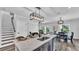 Modern kitchen with a marble island, stainless steel sink, and stylish lighting fixtures, with living area beyond at 6421 Highlands Oak Trl, Lakeland, FL 33813