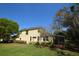 Back exterior showing mature landscaping and a neutral colored two story home at 6620 Lake Clark Dr, Lakeland, FL 33813