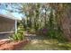 Backyard featuring a screened in porch, mature trees, and landscaping at 6620 Lake Clark Dr, Lakeland, FL 33813