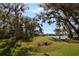 Picturesque backyard with mature trees and a serene view of the lake at 6620 Lake Clark Dr, Lakeland, FL 33813