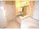 Bathroom features a single sink vanity, tiled floor, and floral wallpaper at 6620 Lake Clark Dr, Lakeland, FL 33813