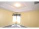 Bright bedroom with carpet, yellow walls, white trim and a window with patterned valance allowing natural light at 6620 Lake Clark Dr, Lakeland, FL 33813