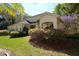 Neutral colored home with mature landscaping, a covered entry and a side entry garage at 6620 Lake Clark Dr, Lakeland, FL 33813