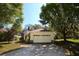 Two car garage with neutral paint, surrounded by mature trees and landscaping in a well manicured neighborhood at 6620 Lake Clark Dr, Lakeland, FL 33813