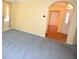 Sunny room with yellow walls, gray carpet, and archway to the front door at 6620 Lake Clark Dr, Lakeland, FL 33813