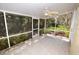 Screened porch with ceiling fan, tile floor, and view of lush landscaping at 6620 Lake Clark Dr, Lakeland, FL 33813
