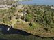 Picturesque aerial view of a lakefront property with boat dock and a mix of lush green trees, providing privacy at 6810 Crystal Beach Rd, Winter Haven, FL 33880