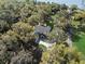 Stunning aerial view of a traditional two-story home nestled among mature trees with a curved driveway at 6810 Crystal Beach Rd, Winter Haven, FL 33880