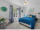 Cozy bedroom with white walls, blue bedspread and curtains, and lots of natural light at 6810 Crystal Beach Rd, Winter Haven, FL 33880