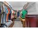 Walk-in closet filled with clothing and containing wooden shelving at 6810 Crystal Beach Rd, Winter Haven, FL 33880