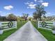 Long driveway with decorative gate leading to a beautiful home surrounded by nature at 6810 Crystal Beach Rd, Winter Haven, FL 33880
