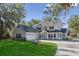 Charming two-story traditional home featuring a covered porch, garage, and lush green lawn at 6810 Crystal Beach Rd, Winter Haven, FL 33880