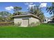 Detached garage with roll-up door and solar panels on a well-maintained lawn offers secure storage and energy savings at 6810 Crystal Beach Rd, Winter Haven, FL 33880