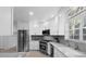 Bright kitchen featuring stainless steel appliances, white cabinets, and wood grain tile floors at 6810 Crystal Beach Rd, Winter Haven, FL 33880