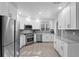 Bright kitchen featuring stainless steel appliances, white cabinets, and wood grain tile floors at 6810 Crystal Beach Rd, Winter Haven, FL 33880