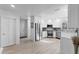 Bright kitchen featuring stainless steel appliances, white cabinets, and wood grain tile floors at 6810 Crystal Beach Rd, Winter Haven, FL 33880