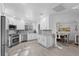 Bright kitchen featuring stainless steel appliances, white cabinets, and wood grain tile floors at 6810 Crystal Beach Rd, Winter Haven, FL 33880