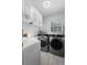 Laundry room with white cabinets, sink, modern washer and dryer, and tile flooring at 6810 Crystal Beach Rd, Winter Haven, FL 33880